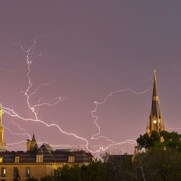 the Golden Dome and the Basilica of the Sacred Heart lit up under criss-crossing lightning