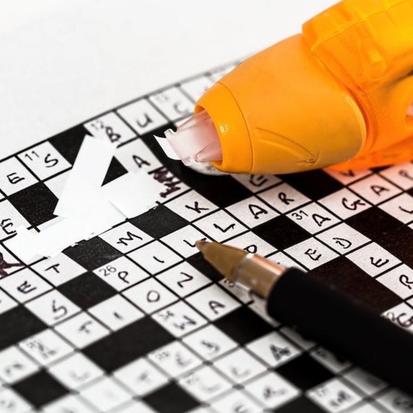 crossword puzzle with pen and white-out pen for corrections