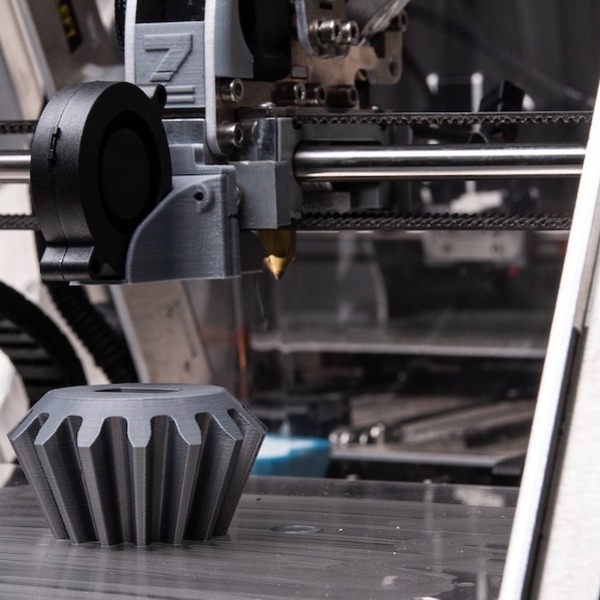 a metal product sitting atop a 3D printer